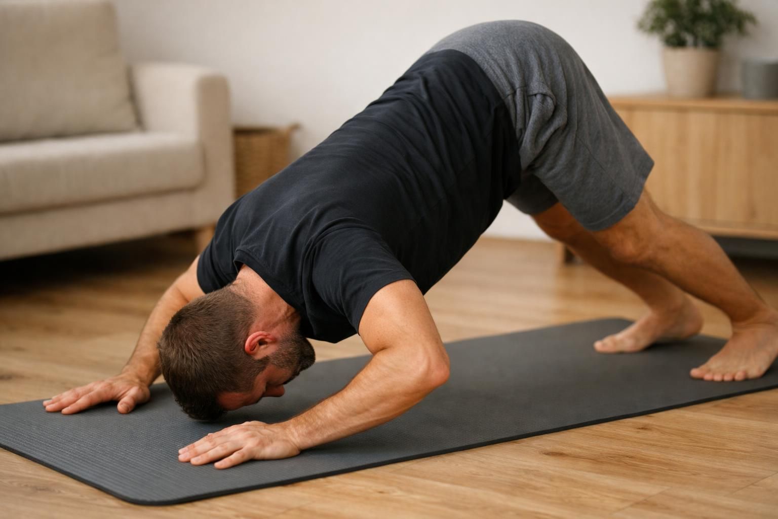 Man doing yoga forearm stretch on black mat