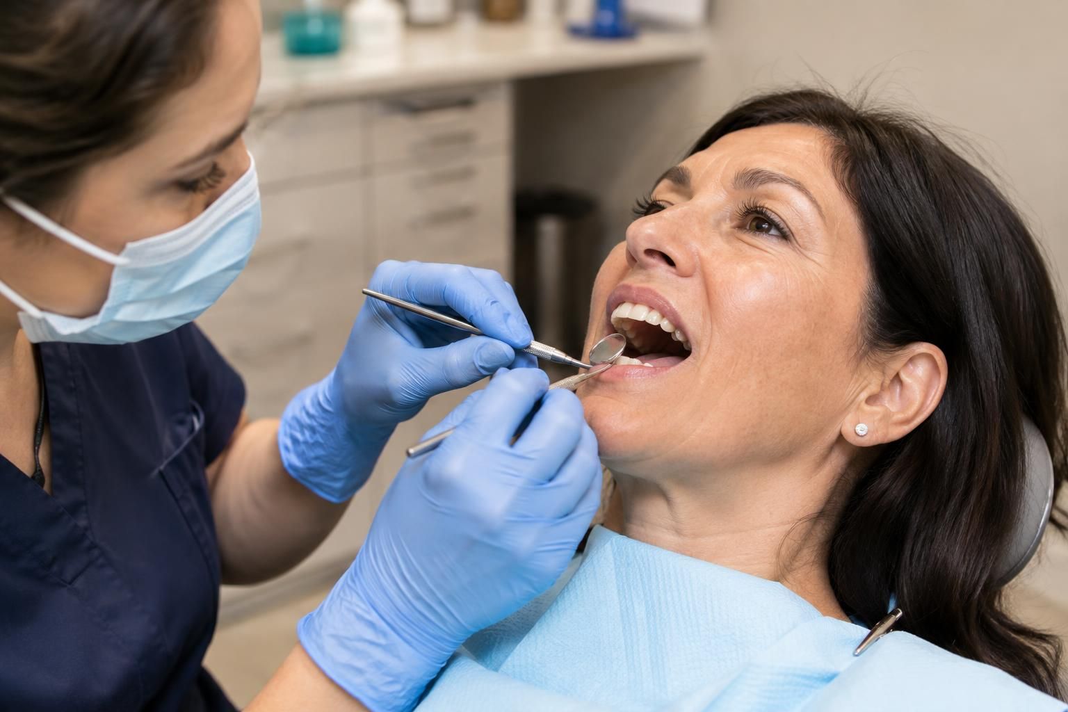 Dentist examining patient’s teeth with mirror and probe