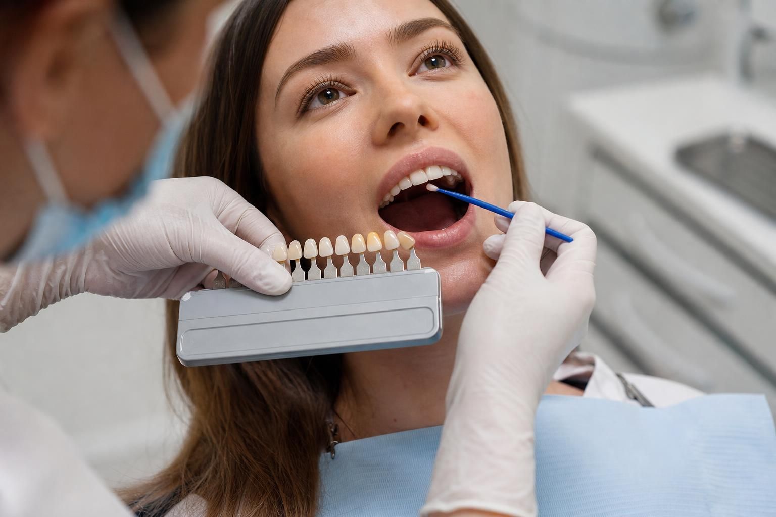 Dentist compares tooth shades and applies bonding material