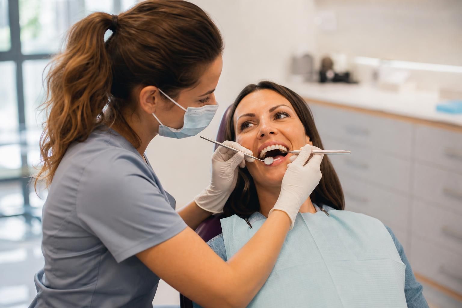 Dentist examines patient’s teeth with mirror and probe