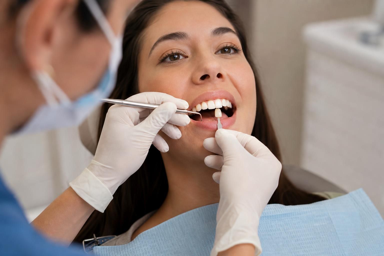 Dentist applies composite to a front tooth with tools
